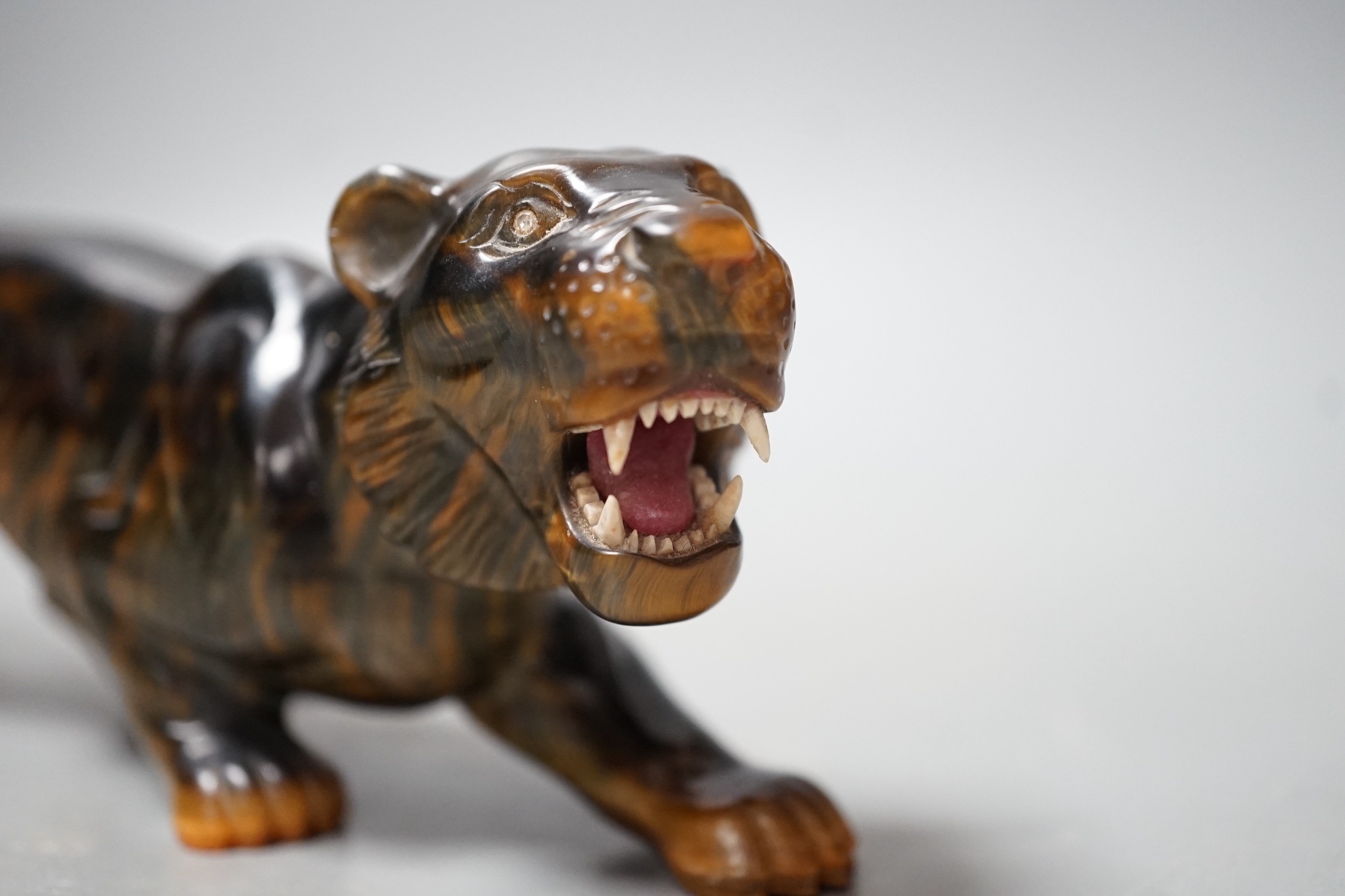 A carved tigers eye model of a tiger with paste set eyes. Makers mark ‘WG’ to paw underside. Numbered 974. 19cm long